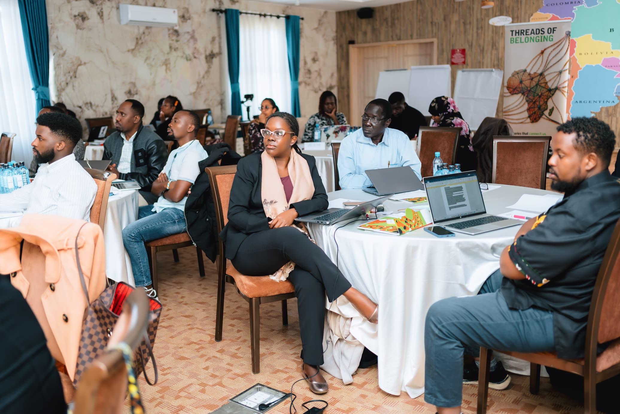 Participants seated around tables at a workshop, following a session